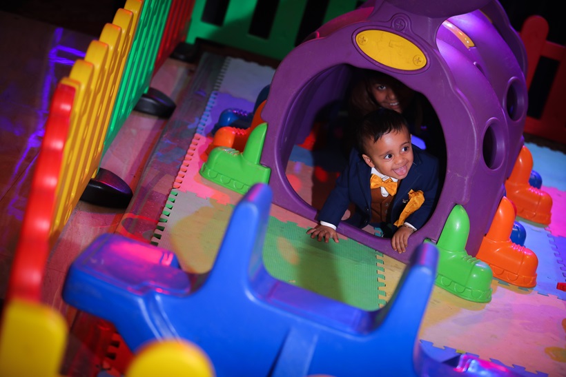 Happy child enjoying a colorful birthday photoshoot in Delhi, surrounded by balloons, cake, and vibrant party decorations – professional kids photography capturing joyful birthday moments.